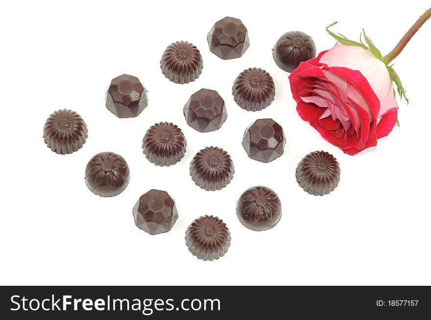 Beautiful red rose and chocolate on white background