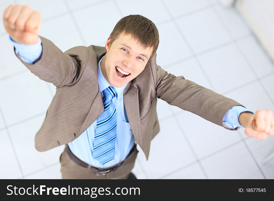 Happy businessman standing outside with arms outstretched