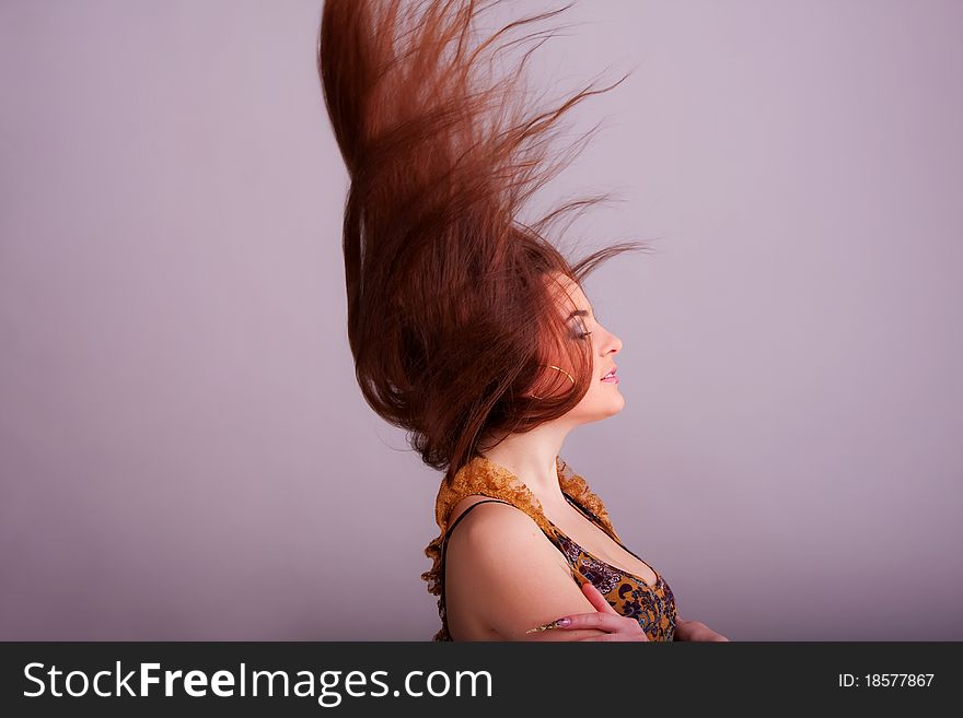 Portrait of a pretty girl with hair fluttering in the wind