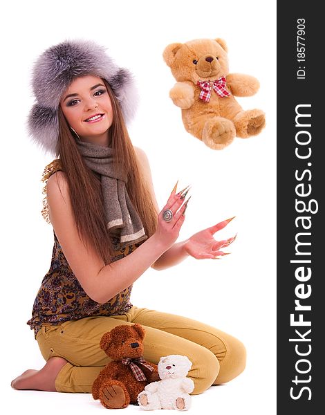 Beautiful brunette in fur hat playing with bear