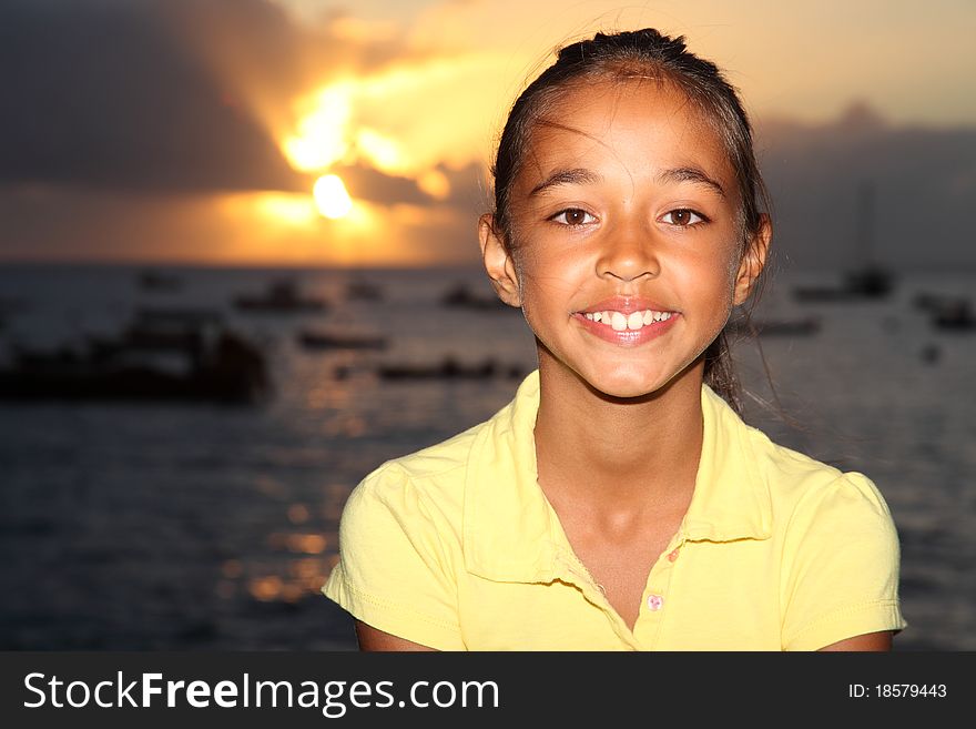 Happy mixed race school girl by seaside at sunset