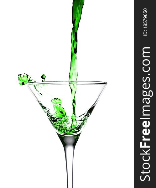 Green drink fall into glass on white background