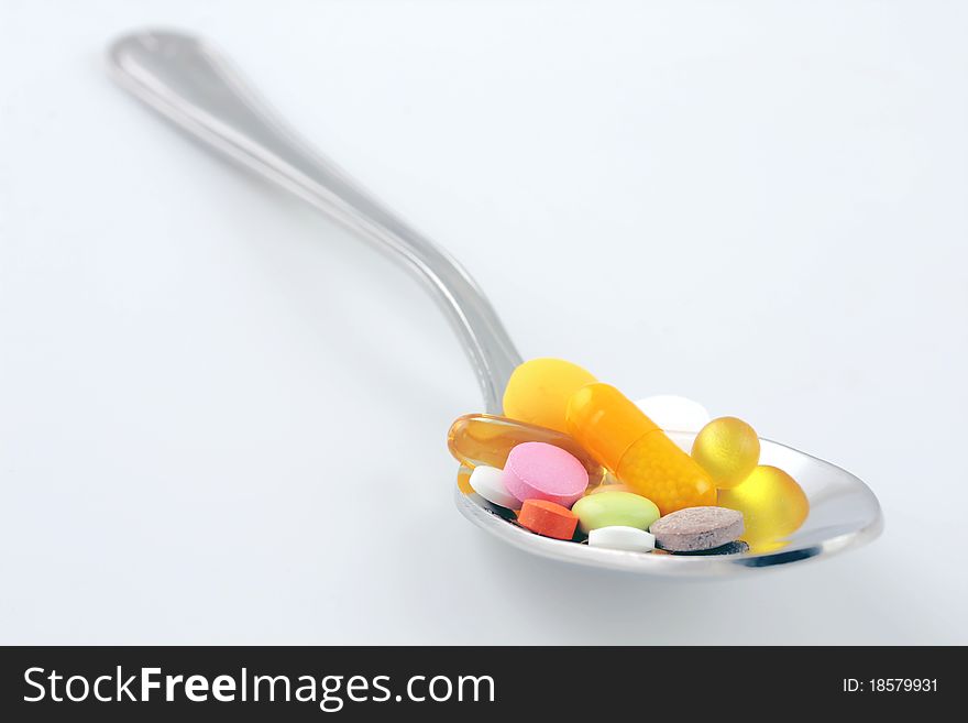 Spoon full of Pills on gray background. Spoon full of Pills on gray background