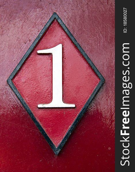 Weathered door number on red wood background. Weathered door number on red wood background