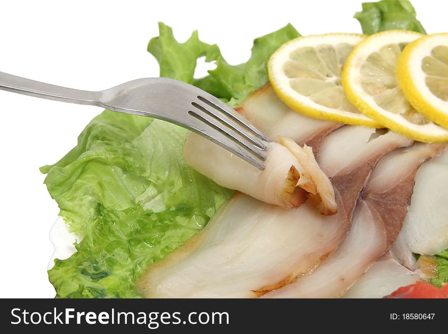 Fork , fish slices and pieces of lemon on the dish. Fork , fish slices and pieces of lemon on the dish