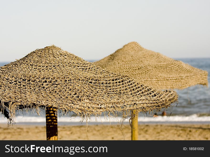 Straw umbrella on the beach sun protecting