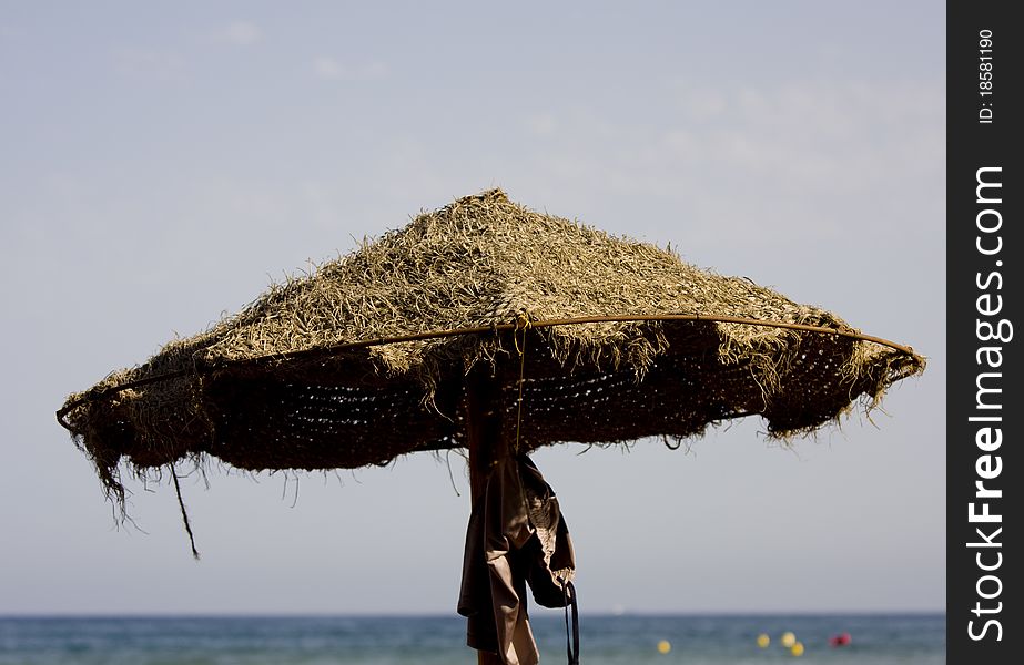 Straw umbrella on the beach sun protecting