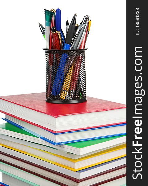 Pile of new books and holder basket in pens isolated on white background