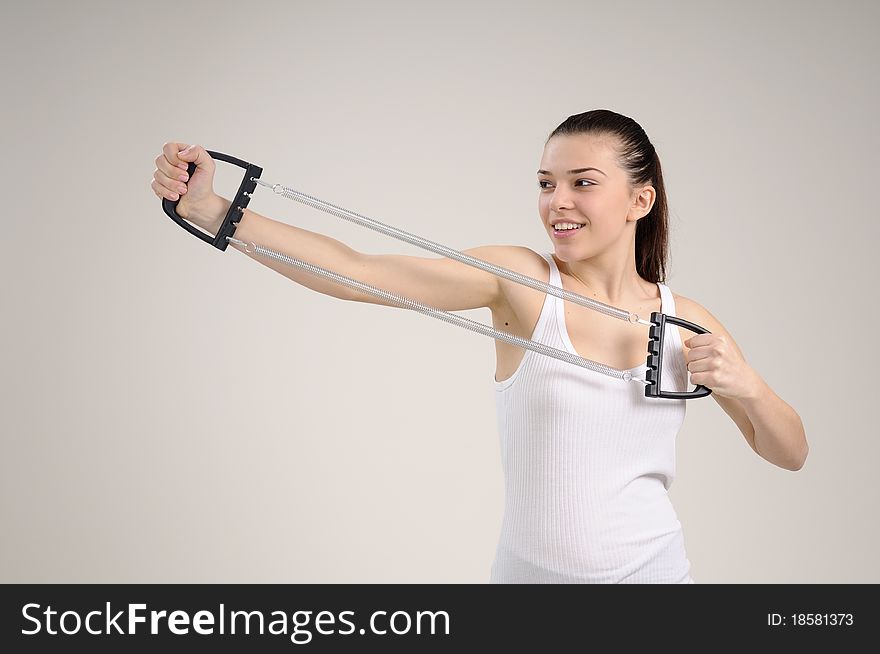 Beautiful young woman practicing fitness and working out her hands muscles. Beautiful young woman practicing fitness and working out her hands muscles