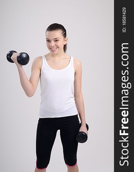 Beautiful young woman working out with dumbbells. Beautiful young woman working out with dumbbells