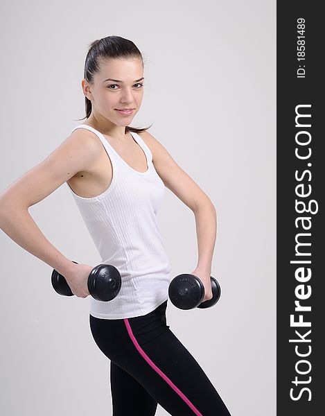 Beautiful young woman working out with dumbbells. Beautiful young woman working out with dumbbells