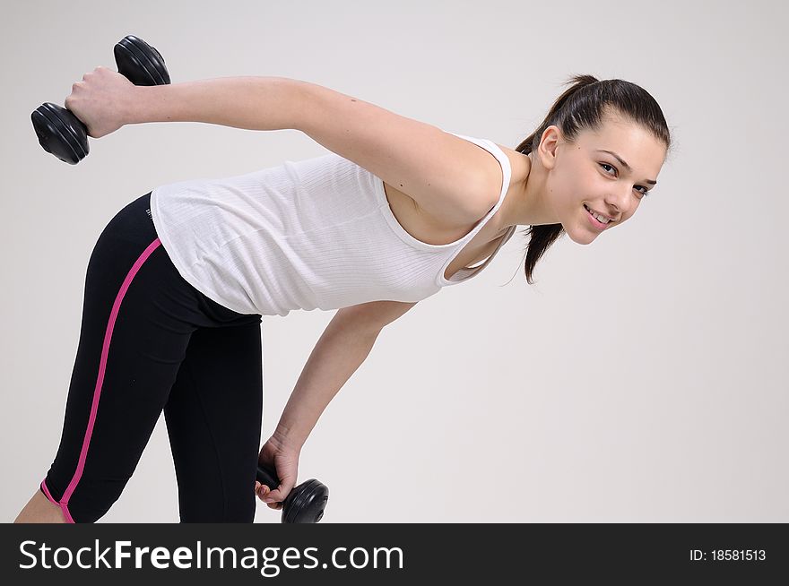 Beautiful attractive girl working out with dumbbells. Beautiful attractive girl working out with dumbbells
