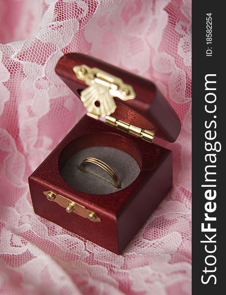 Gold ring in box sitting on lace. Gold ring in box sitting on lace