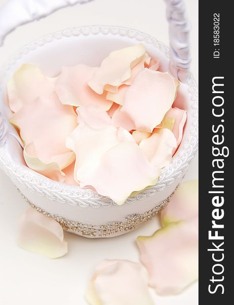 White basket filled with pink rose petals. White basket filled with pink rose petals