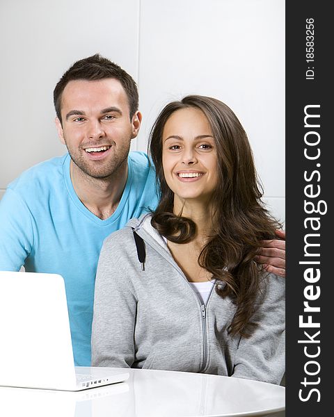 Young couple with laptop in white interior