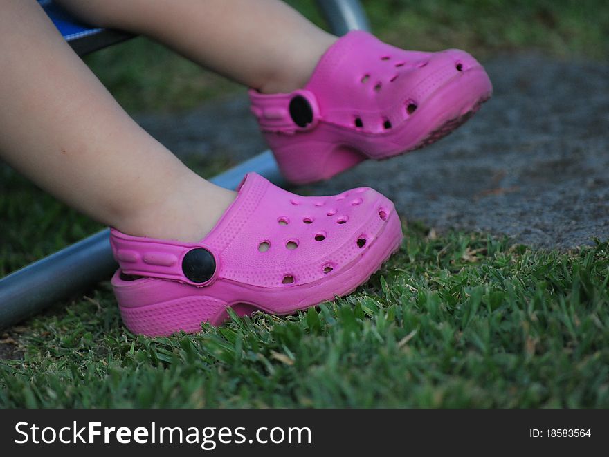 Pink small shoes on the feet of a kid. Pink small shoes on the feet of a kid