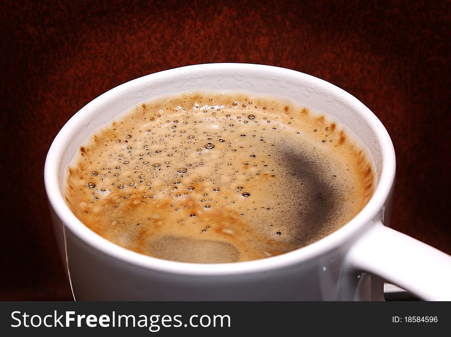 Coffee with cream on a brown background.