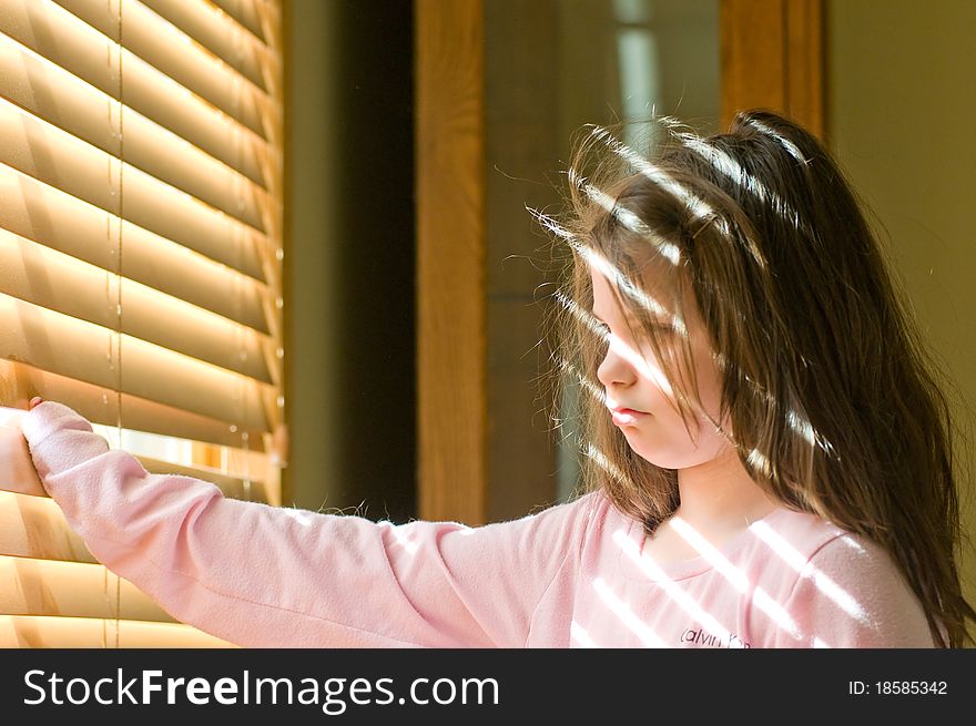 A picture of a young girl stuck inside wishing she were outside. A picture of a young girl stuck inside wishing she were outside