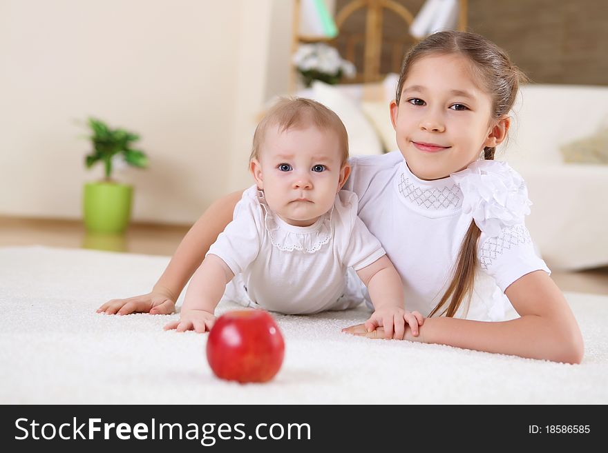 An older sister playing with a toddler sister at home. An older sister playing with a toddler sister at home