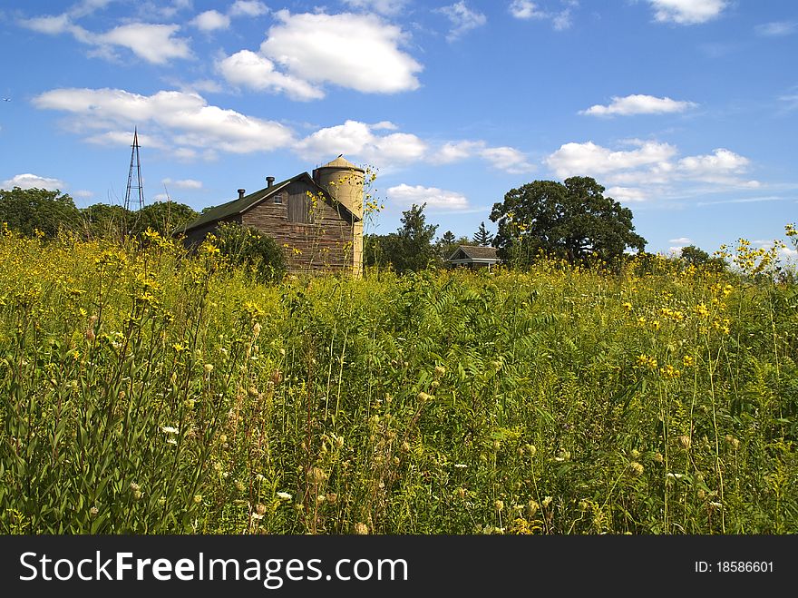 Old barn and farmhouse across a meadow. Old barn and farmhouse across a meadow
