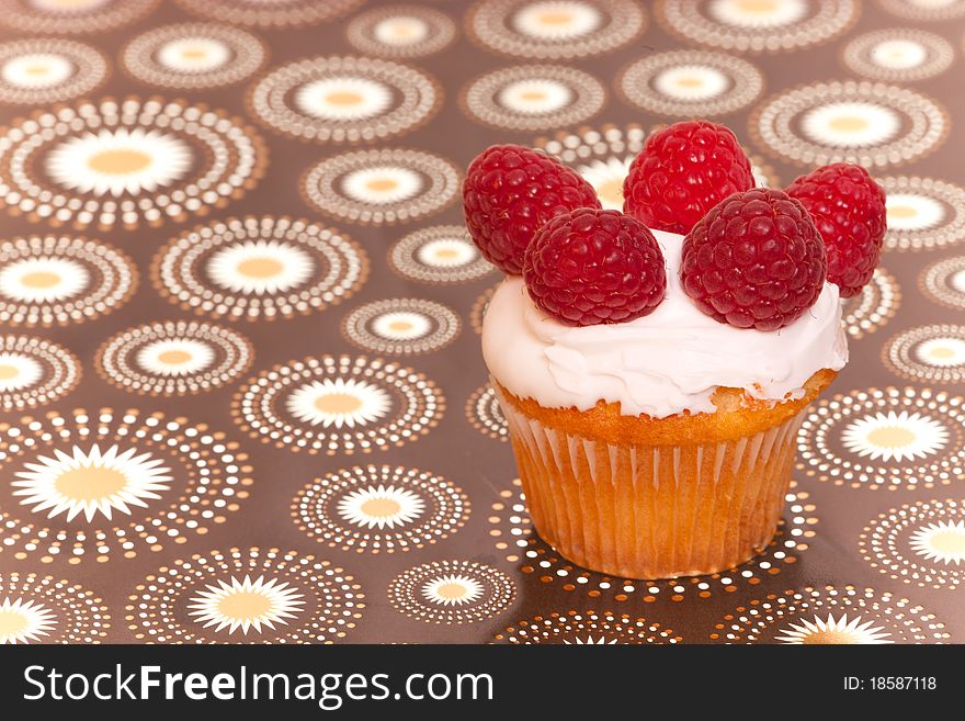 Cup cake with raspberries on nice interesting background