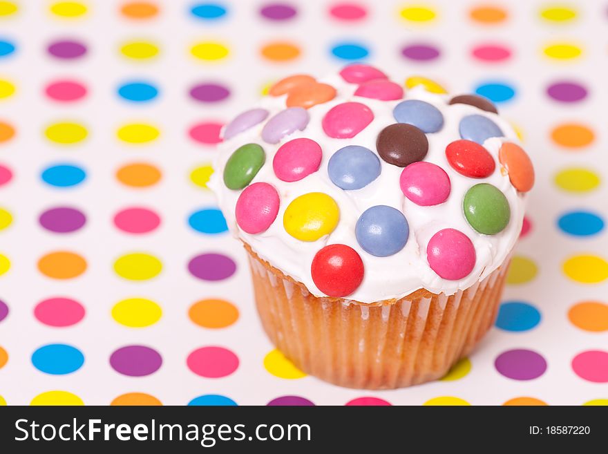 Decorated cup cake on spotty background