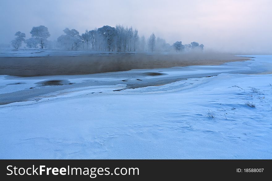 Calm winter landscape of a lake and trees during sunrises,jilin,china.