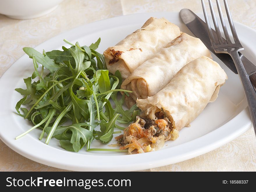 Fresh duck spring rolls with rocket on a plate