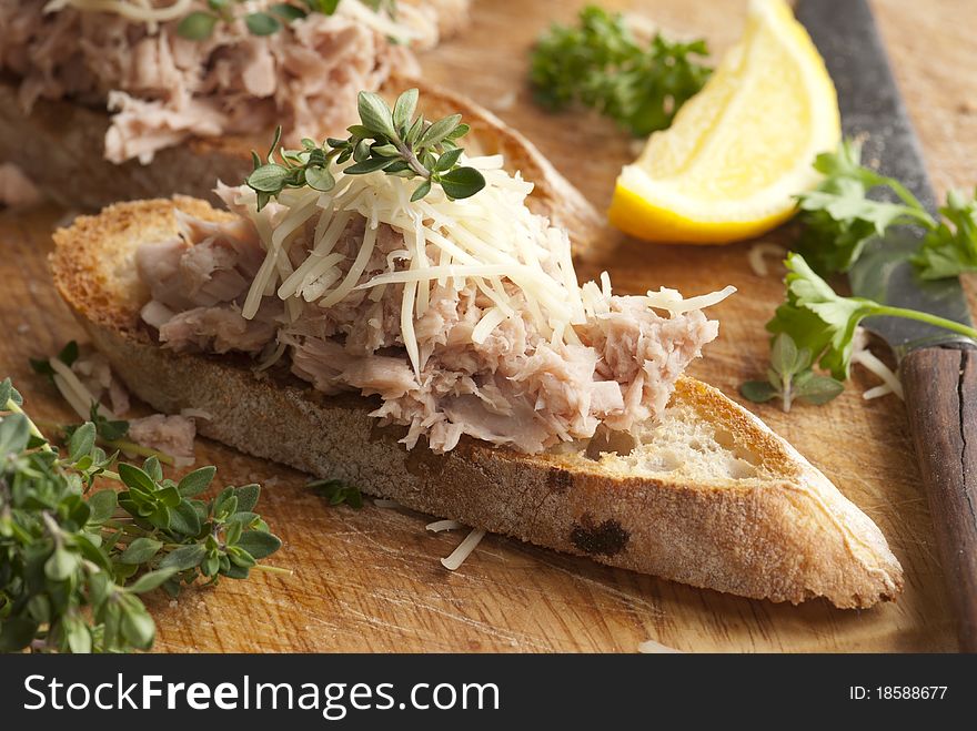 Toasted bread topped with tuna and grated cheese