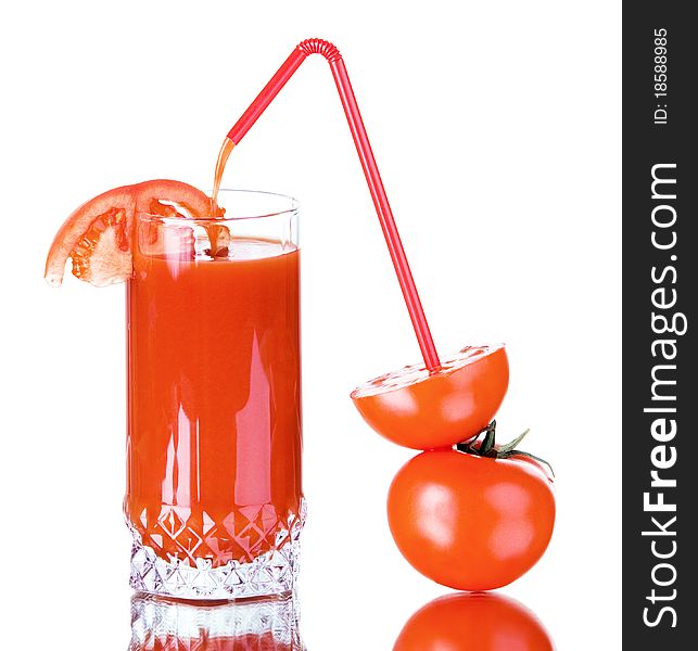 Juice from a ripe tomato through a tubule is poured in a glass. Juice from a ripe tomato through a tubule is poured in a glass