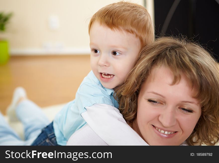 Young mother having fun with her little son at home on the floor. Young mother having fun with her little son at home on the floor