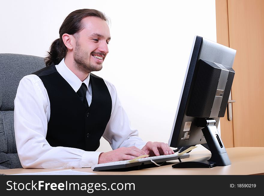 A young business man working on the computer in the office.