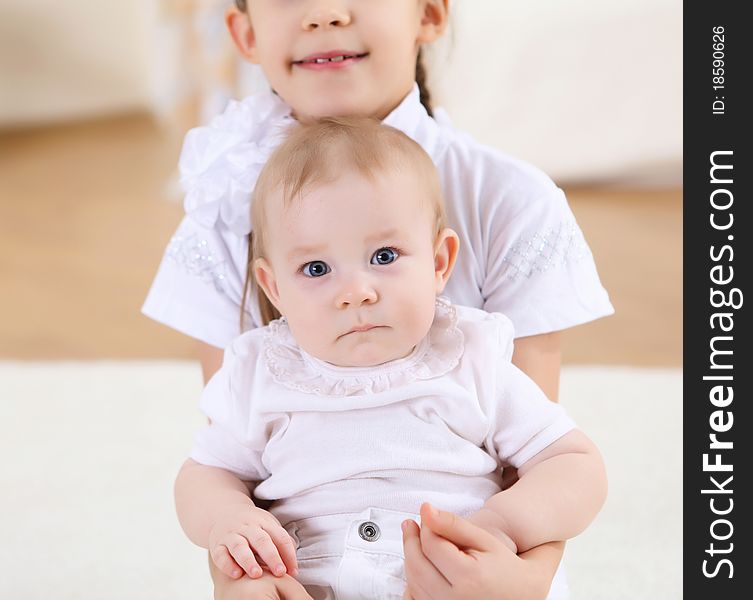 An older sister playing with a toddler sister at home. An older sister playing with a toddler sister at home