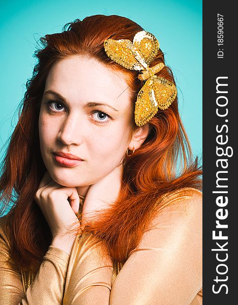 Beautiful girl with a golden butterfly in her hair