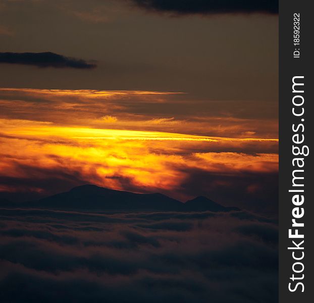 Sunset in the Alps above a sea of clouds covering the valley below. Sunset in the Alps above a sea of clouds covering the valley below