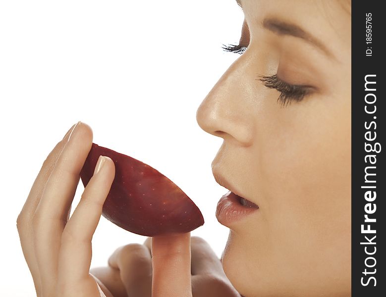 Young woman enjoying a piece of red apple portrait close up