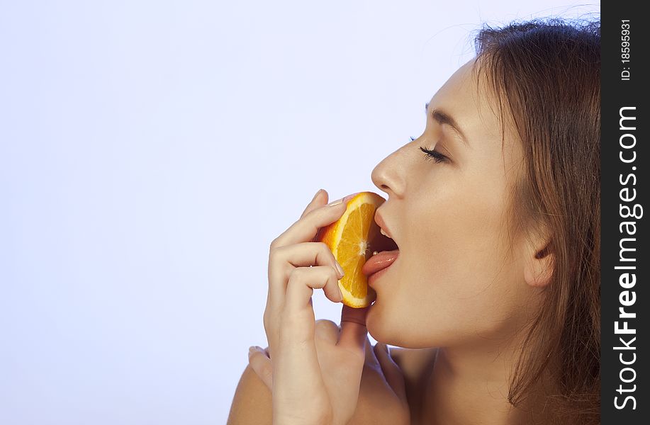 Young Woman Enjoying A Slice Of Orange