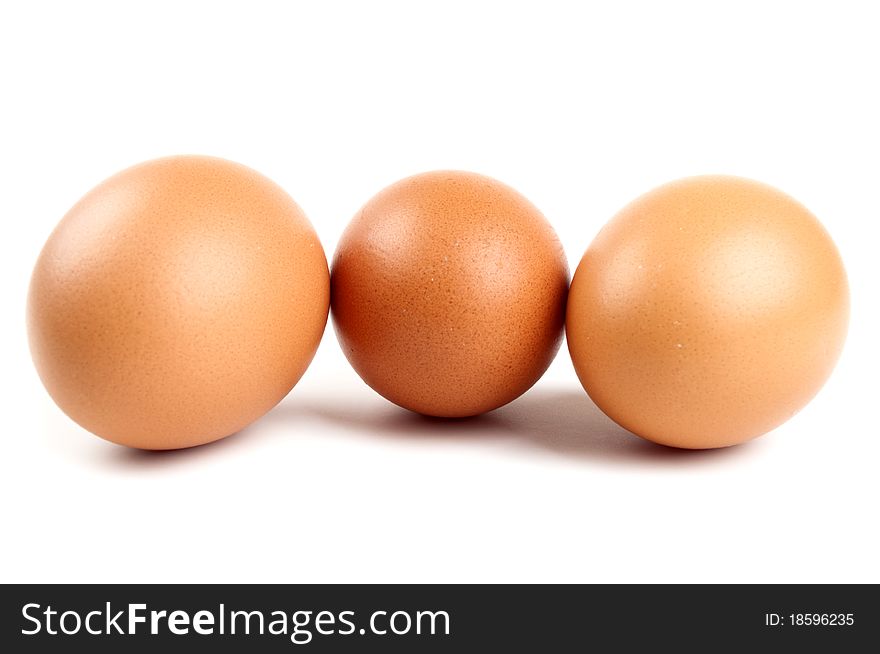 Three eggs in a carton on a white background