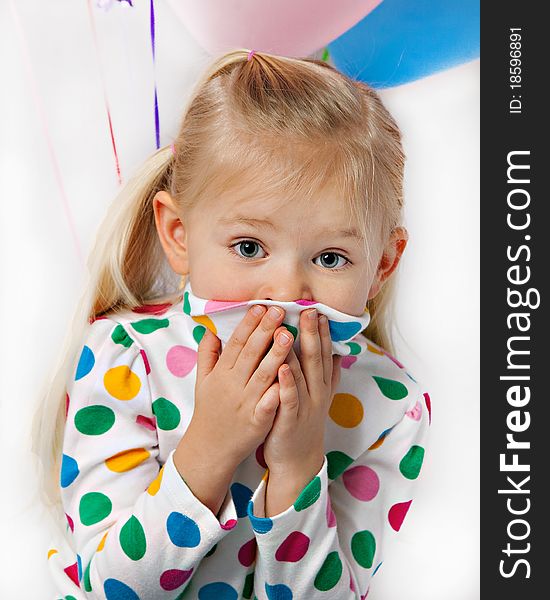 A young girl, about four years old, wearing a polka-dot shirt, with balloons in the background.  She has an interesting expression of surprise. A young girl, about four years old, wearing a polka-dot shirt, with balloons in the background.  She has an interesting expression of surprise.