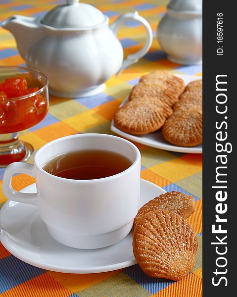 Cup of tea and cookies in the form of shells, sprinkled with sugar. Cup of tea and cookies in the form of shells, sprinkled with sugar.