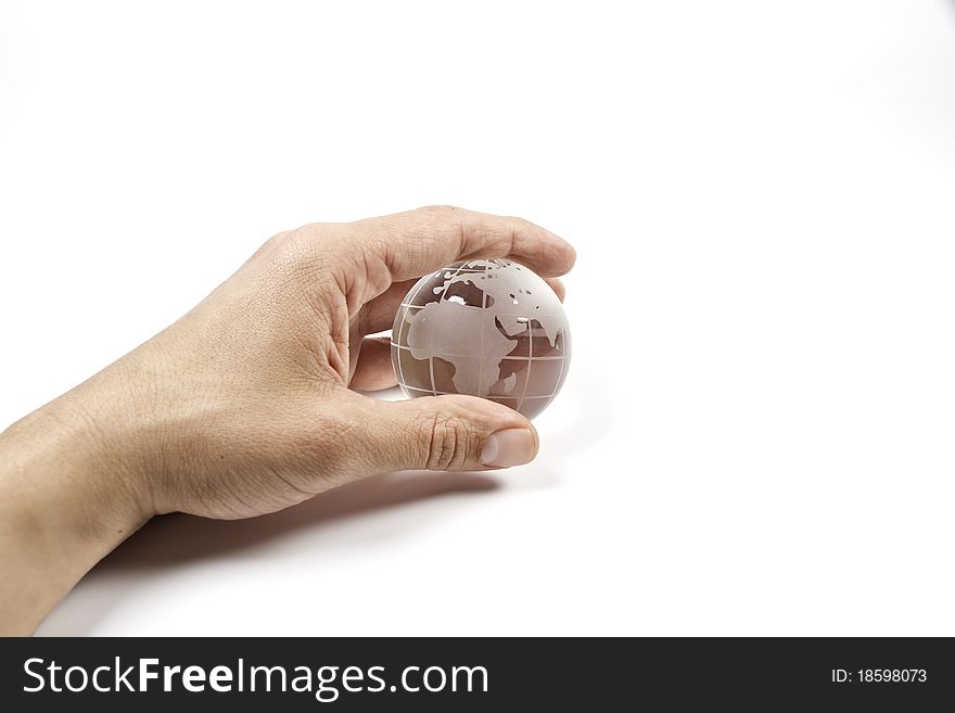 A hand holding a glass miniature of the world. A hand holding a glass miniature of the world
