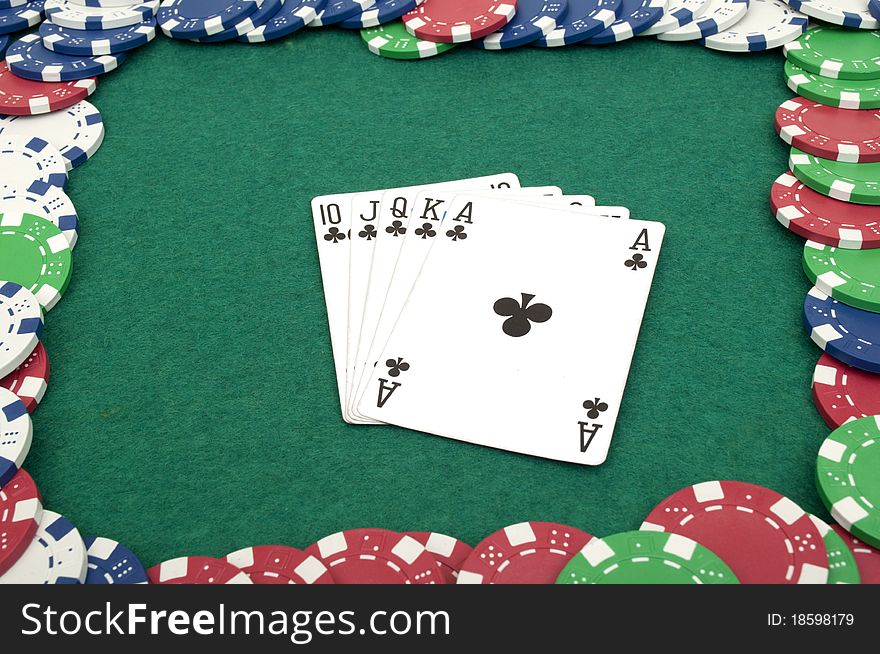 Royal flush and chips on a green table