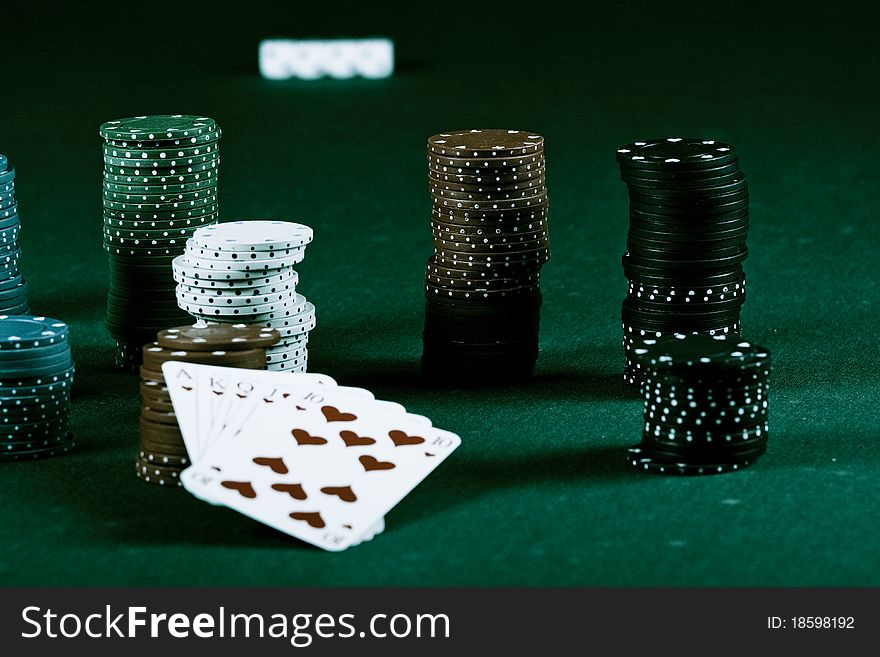 Casino gambling chips and playing cards on green table. Casino gambling chips and playing cards on green table