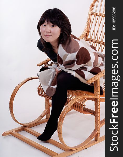 Attractive young Asian woman sitting in the rocking-chair
