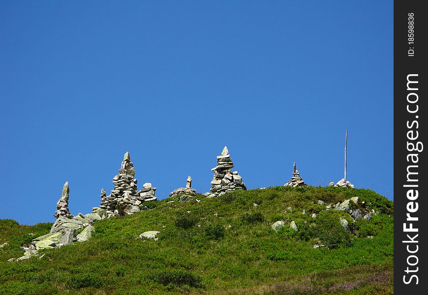 Very green grass and very blue sky give a feeling of space and timelessness. Tourists heap stones as signs. Very green grass and very blue sky give a feeling of space and timelessness. Tourists heap stones as signs.