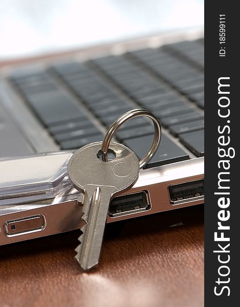 Key with a trinket on the keyboard of notebook