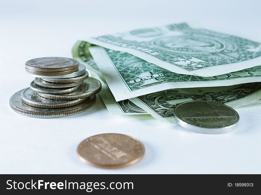 Stacked coins and dollar bills isolated on a white background. Stacked coins and dollar bills isolated on a white background