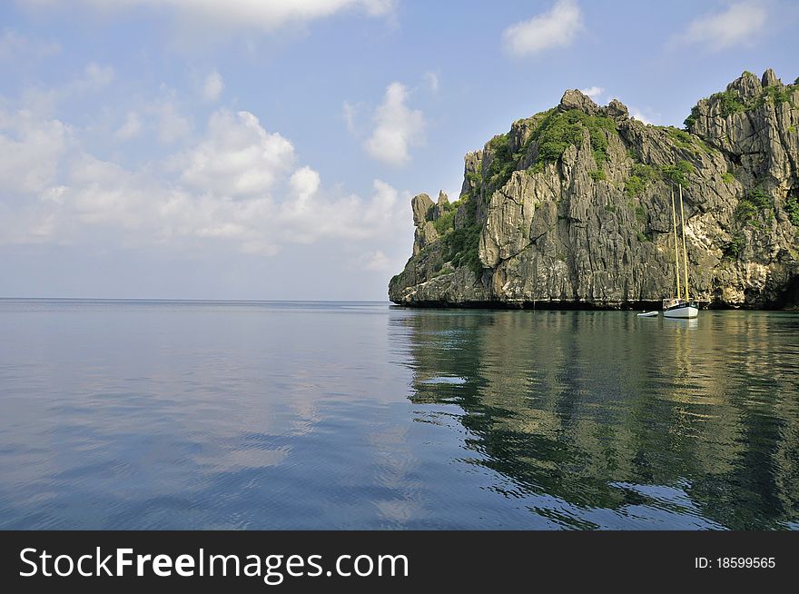 Thai island with yacht in calm water