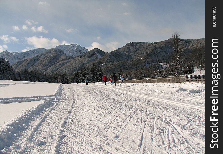 Beautiful winter landscape showing a cross-country ski run with people skiing