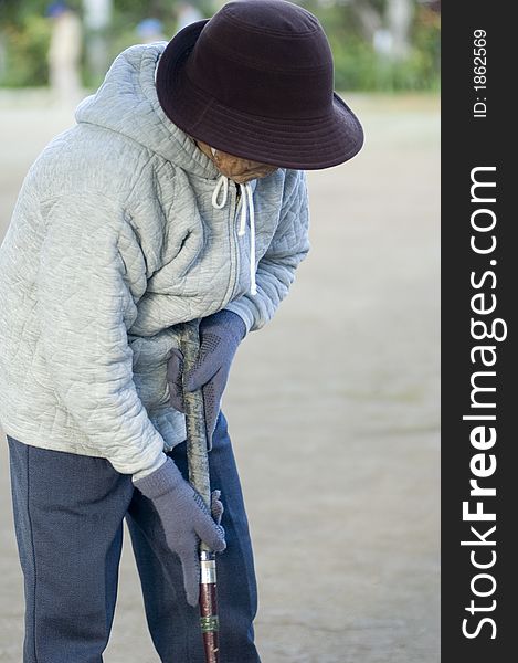 Old Asian woman playing game ball in the cold